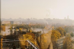 A view from a high-rise building overlooking a cityscape with trees and a river. - WN Hotel (Sofia)