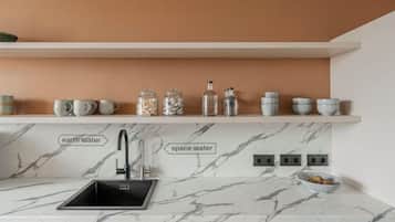 A kitchen with a marble countertop, a sink, and labeled water sources.