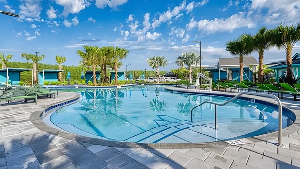 A circular pool with a clear blue sky and scattered clouds in the background. - Disney 4BR w/ Pool + Themed Rooms in Storey Lake (Kissimmee)