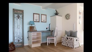 A room with a desk, chair, and storage unit.