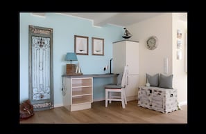 A room with a desk, chair, and storage unit.