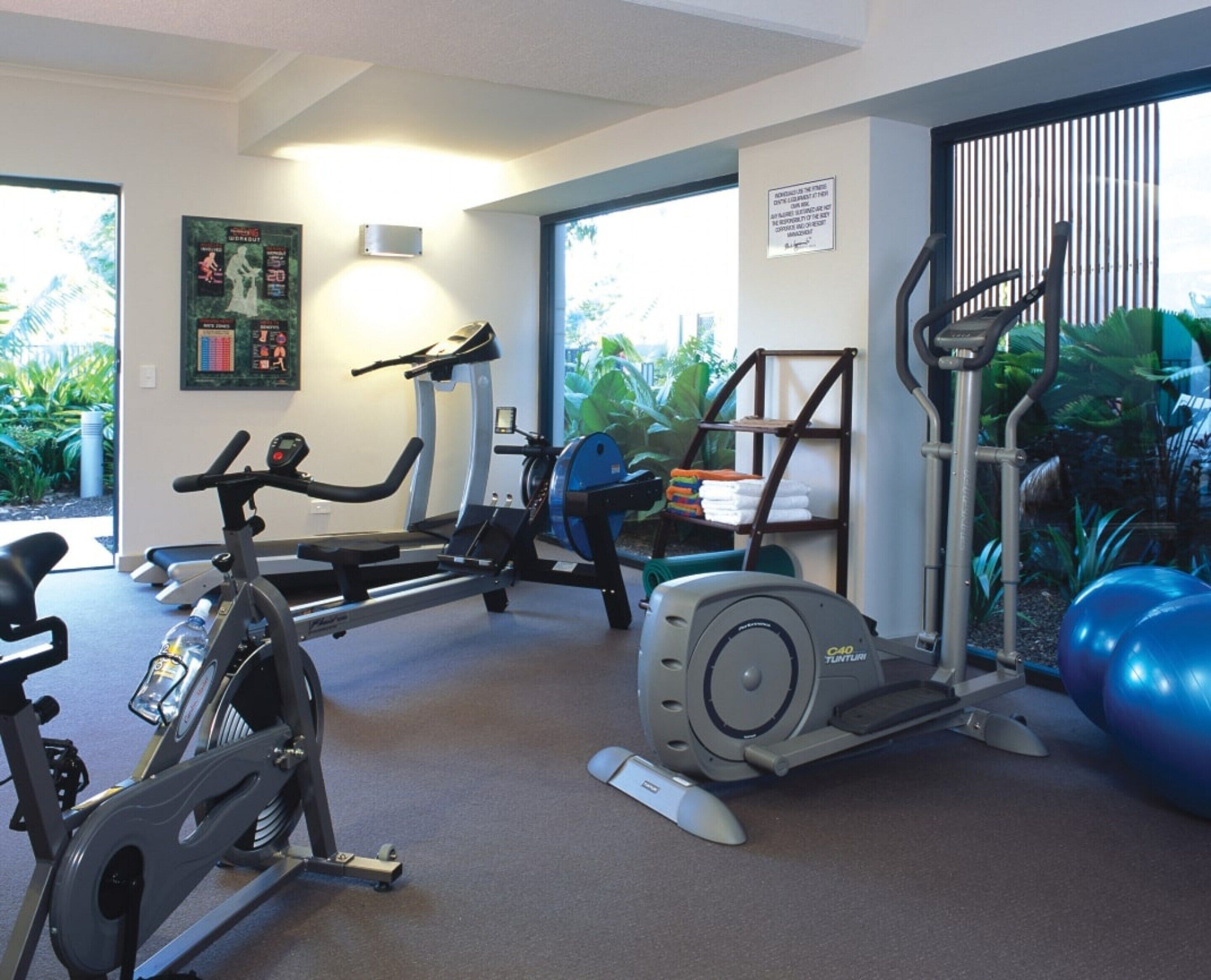 A gym with stationary bikes, a treadmill, and exercise balls.