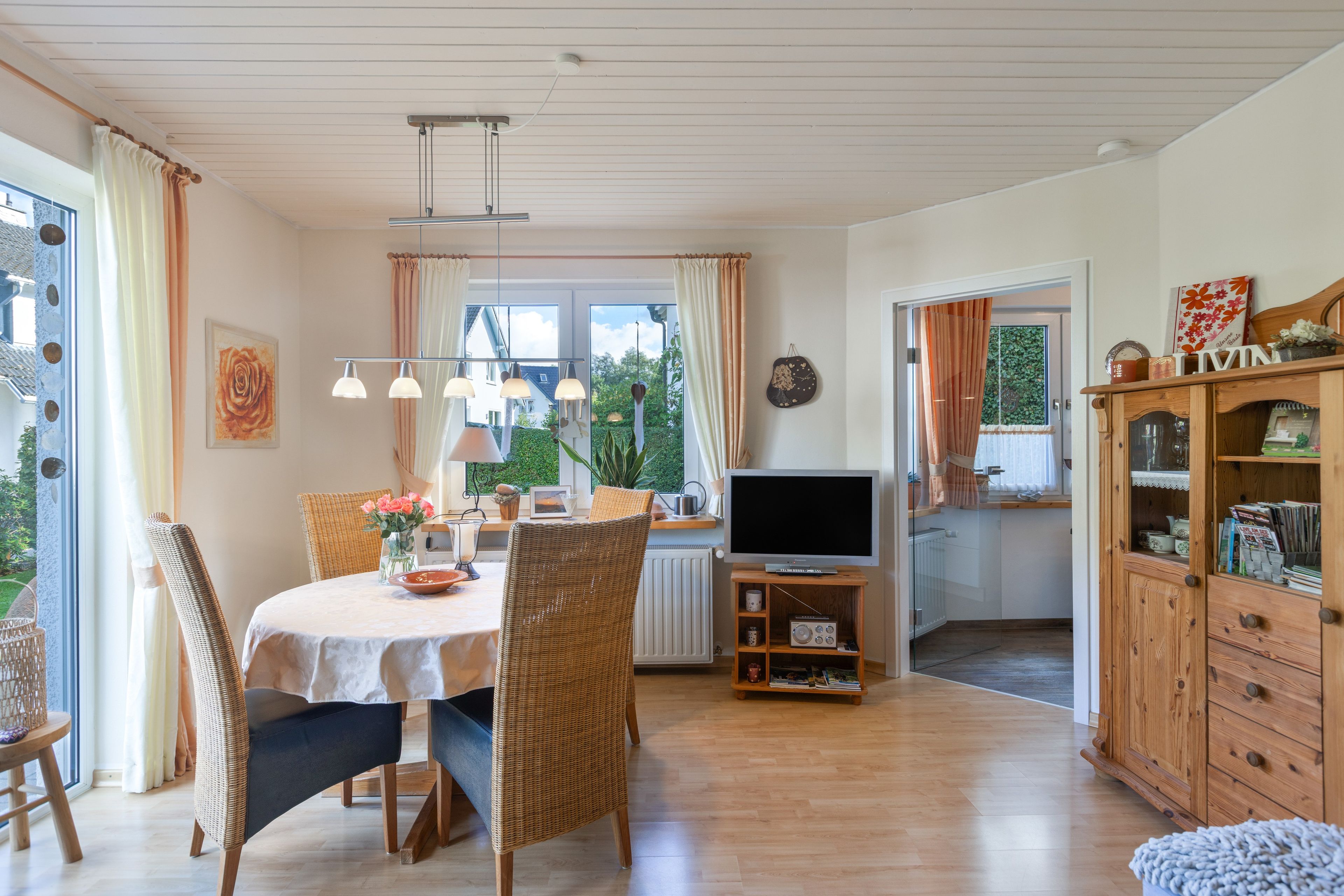 Spiseområde med bord, stole og et fjernsyn.