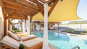 A poolside area with wooden pergolas, lounge chairs, and a pool. - Arcadia Oasis | Heated Pool & Near Old Town (Phoenix)