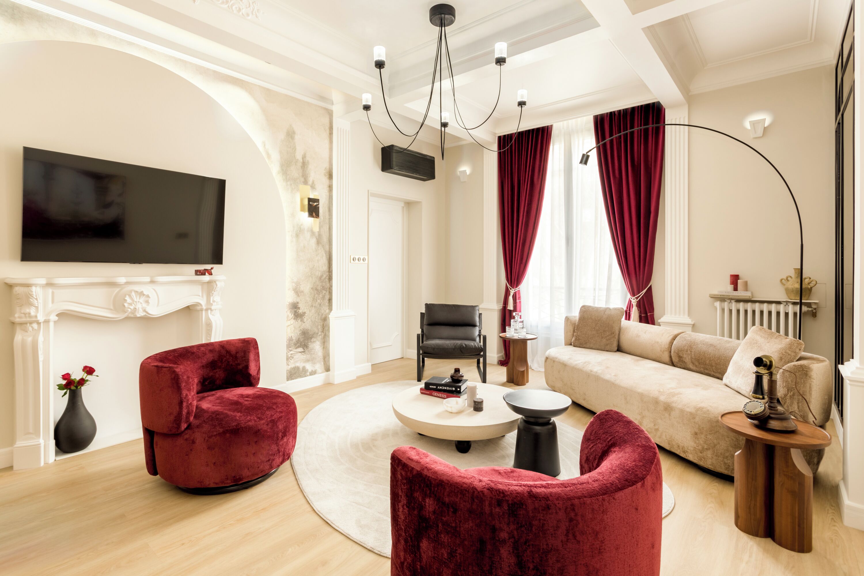 A spacious living room with a fireplace, a television mounted on the wall, and a sofa.
