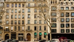 A multi-story building with a classic architectural style, featuring a central entrance with a large door and multiple windows on each floor. - Merveil Signature Suite - Kleber (Paris)