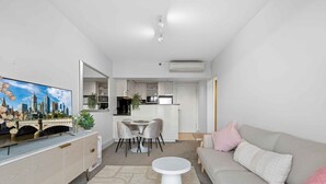 Un salon moderne comprenant un canapé, une table basse et un coin repas avec des chaises et une table.