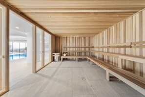 A modern interior with wooden panel walls, a long bench, and a small table with a pitcher. - Phillip 2-bed: Chic Interiors, Amazing Amenities (Canberra)
