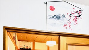 Een traditionele Japanse kamer met tatami vloeren, een laag bed en een schuifdeur.