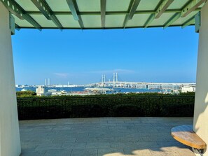 A covered outdoor seating area with a view of a port and a bridge. - Ideal for sightseeing in Yokohama Chinatown, Motomachi, and Yamate|Quiet, comfortable home (62 square meters)|Easy access to Kamakura! (Yokohama)