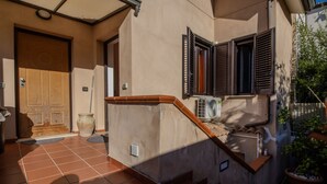 Un immeuble résidentiel doté d’un escalier en bois, d’une façade de couleur beige et d’une terrasse carrelée.