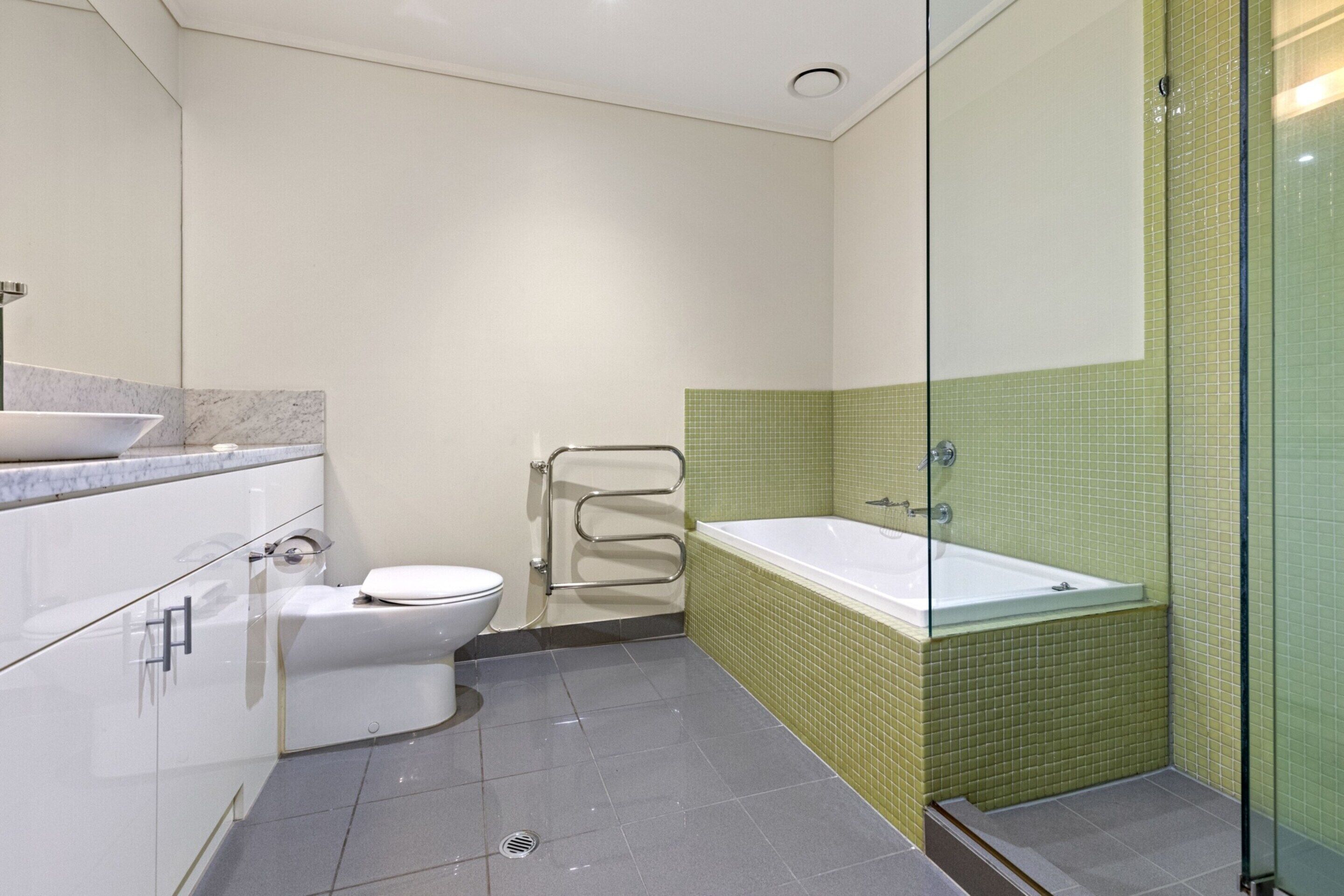 A modern bathroom with a toilet, sink, and bathtub.