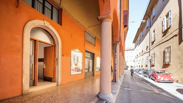 A street with buildings, a cyclist, and parked cars. - HouSmart Val D'Aposa 5  (Bologna)