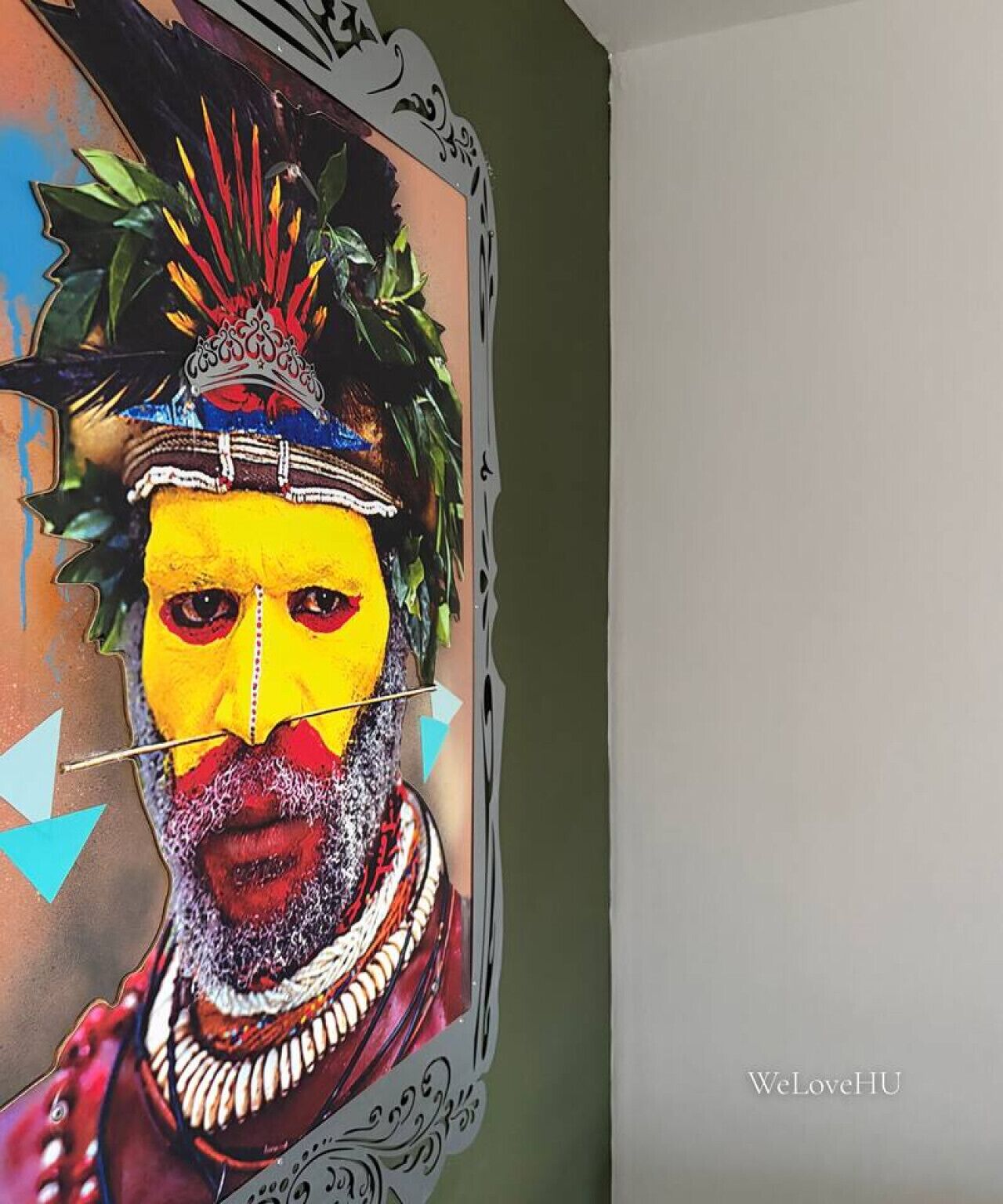 Un mur orné d’une fresque colorée représentant une personne portant un couvre-chef et des bijoux.