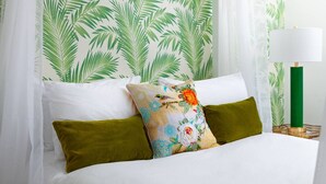 A bed with white bedding, green and floral pillows, and a canopy. - We Love HU -Sky Marina Suite (Kingston upon Hull)