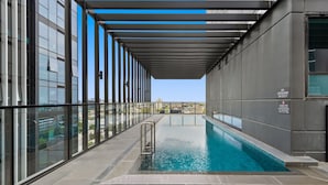 A modern indoor pool with a clear view of the cityscape through large windows. - Sophisticated 2-bed With Bay Views & Amenities (Melbourne)