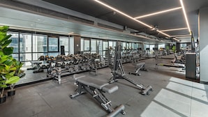 A modern gym with various exercise equipment, large windows, and a clean, well-lit interior. - Sophisticated 2-bed With Bay Views & Amenities (Melbourne)