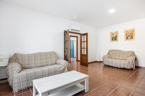 Un salon comprenant un canapé, une table basse et une porte donnant sur une autre pièce.