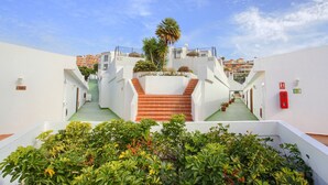 Un hotel con una scalinata centrale, diversi piani e cielo sereno.