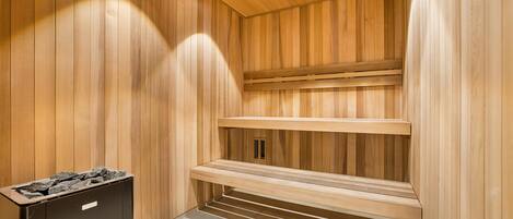 A sauna room with wooden walls and benches.