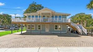 A two-story building with a balcony and a sign indicating it is a rental property. - A Block Away- 5 BR/3BA- Dog Friendly- Pool (North Myrtle Beach)