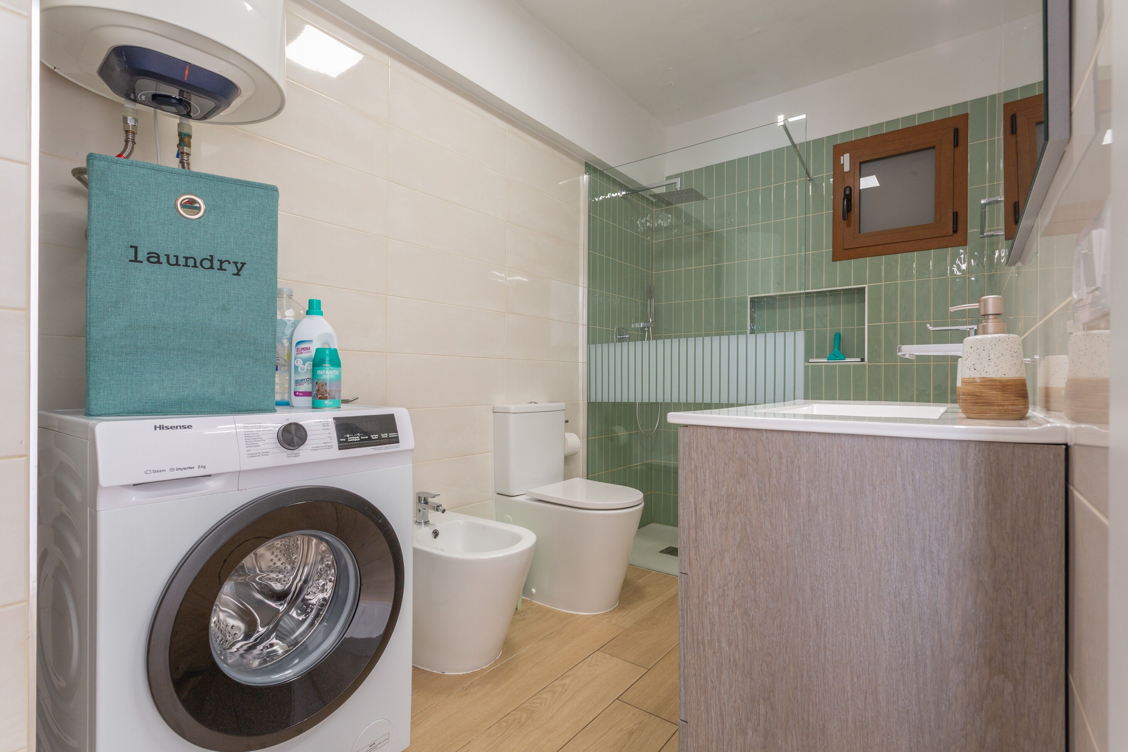 A modern bathroom with a washing machine, bidet, toilet, and a mirror above the sink.