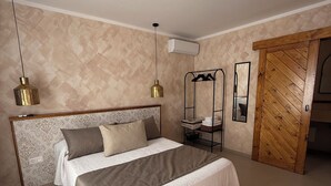 Quarto com cama, luminária pendente, espelho e guarda-roupa.