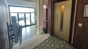 A staircase leading to a room with a patterned floor, a door with a vertical handle, and a view of the outside through a glass door. - 'Between Sky and Sea by Vale' Apartment with Balcony and Air Conditioning (Fano)