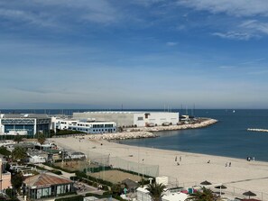 A coastal area with a beach, a marina, and a large building with multiple windows and a flat roof. - 'Between Sky and Sea by Vale' Apartment with Balcony and Air Conditioning (Fano)