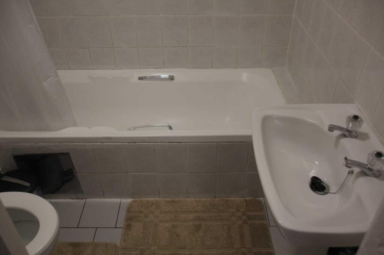 Een badkamer met een bad, een wastafel en een toilet.