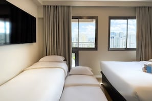 A hotel room with two beds, a flat-screen TV, a city view, and a window with curtains.