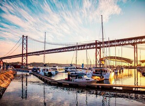 A marina with boats docked under a large bridge. - Lisbon Dreams LxFatory (Lisboa)