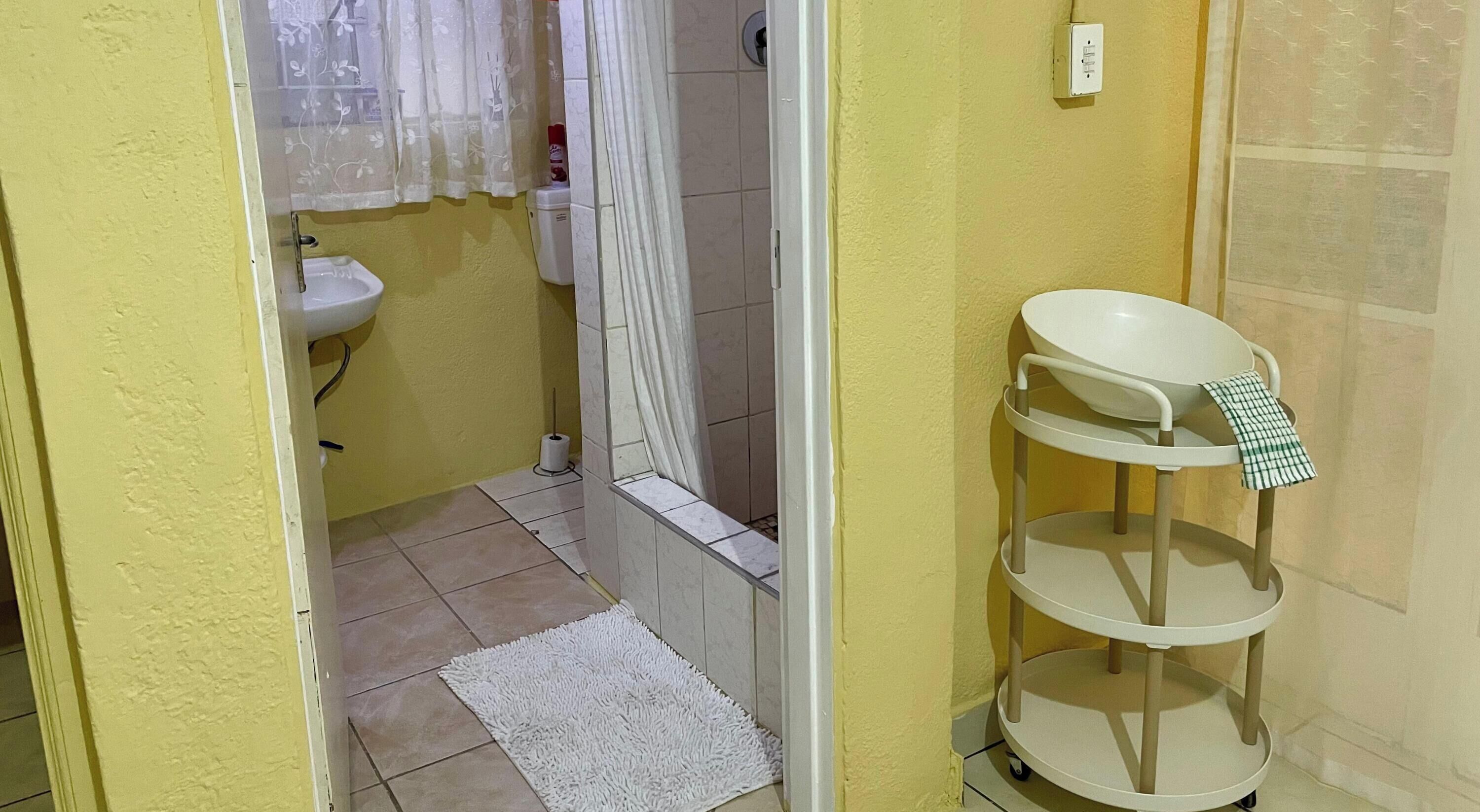 A bathroom with a sink, toilet, and shower curtain.