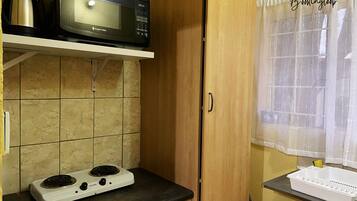 Una cocina con microondas, estufa y armarios de madera.