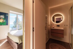 A bedroom with a bed, a window, a bathroom with a mirror, and a wall-mounted shelf. - Villa Rossa - by My Home in Como (Brunate)