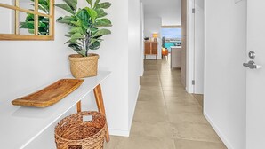 A hallway with a potted plant, a wooden tray, and a wicker basket. - 3-bed: Riverfront Alfresco Dining & Rooftop Pool (Batemans Bay)