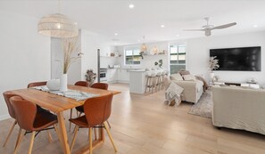 Un espacio habitable moderno y abierto con comedor, cocina y zona de estar.