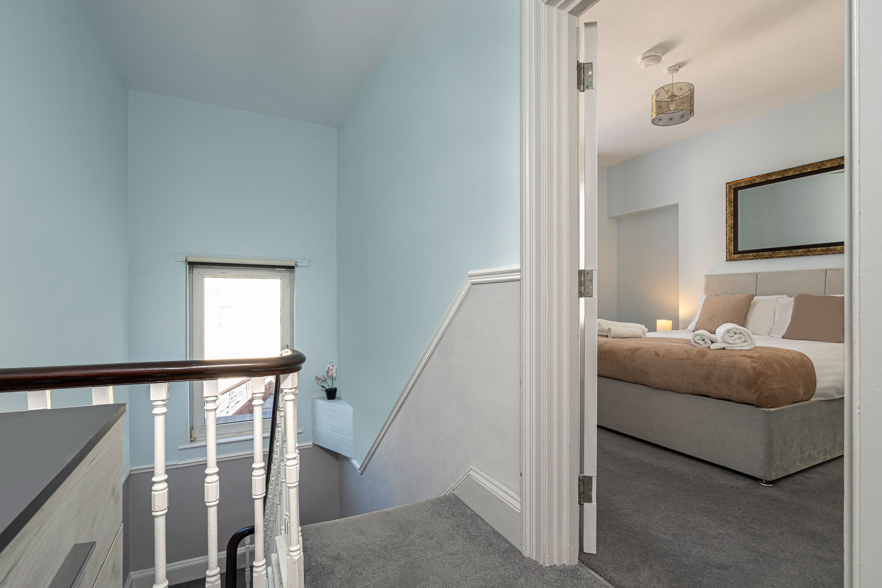 Ein Schlafzimmer mit einem Bett, einem Fenster und einer Treppe.