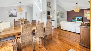 A modern living space with a dining area, kitchen, and seating area. - Riverside 3-bed Townhouse With Spacious Deck & BBQ (Mossy Point)