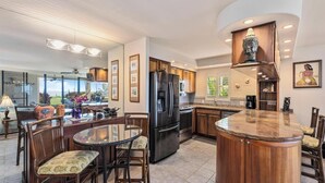 Una cocina moderna con una isla central, armarios de madera y un refrigerador empotrado.