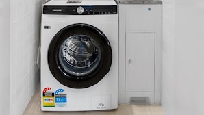 A compact laundry area with a front-loading washing machine, a built-in dryer, and a sink. - Spacious and Superb 3-bed Apartment (Brisbane)
