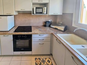 A kitchen with a stove, oven, microwave, toaster, and sink.
