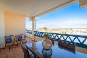 Ein Balkon mit Tisch, Stühlen und einem Blumenstrauß.
