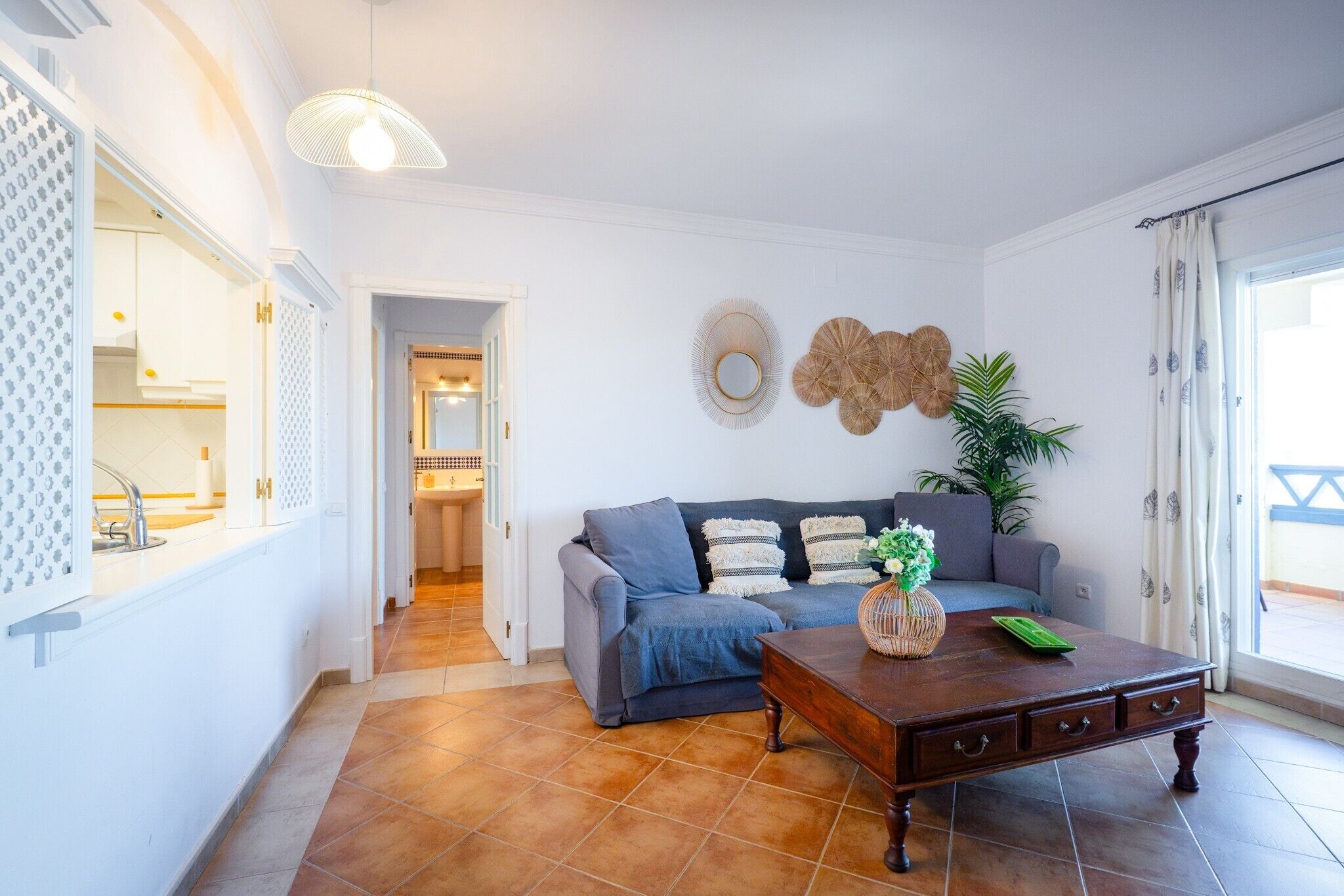 A living room with a sofa, a coffee table, and a decorative mirror.