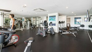 Uma academia com diversos equipamentos de exercício, incluindo esteiras, bicicletas ergométricas e aparelhos de musculação.