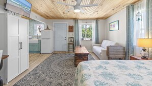 A room with a bed, a desk, a chair, a TV, a ceiling fan, and a window with curtains. - 🏖️Short Walk to Beach - Perfect for Families - Terrapin Station🏖️ (New Smyrna Beach)