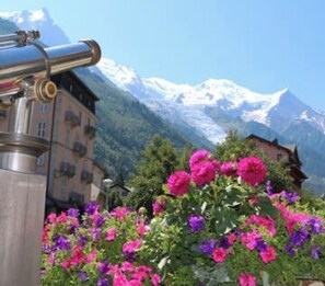 A building with a balcony overlooking a mountain range.