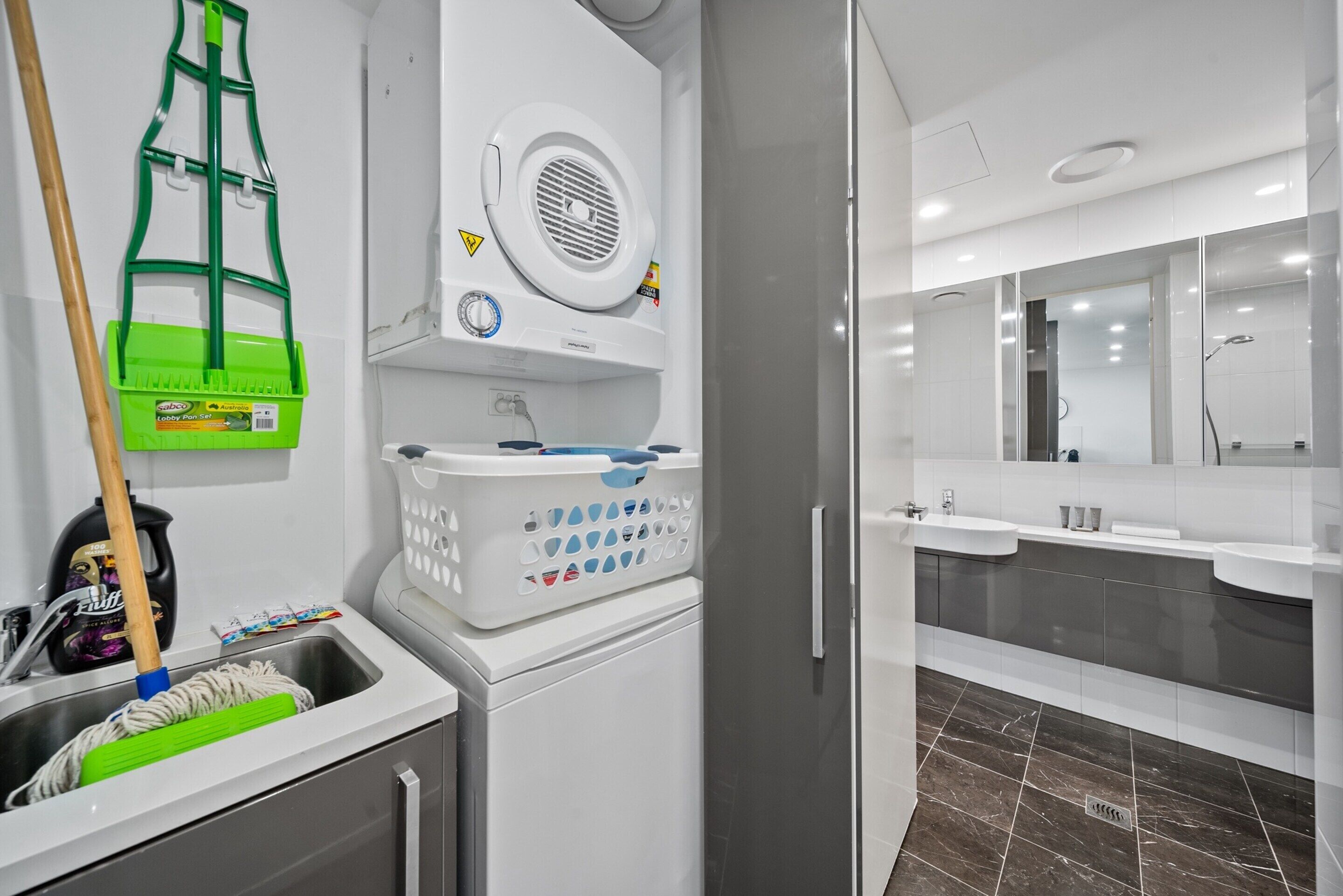 A modern bathroom with a sink, mirror, and shower.