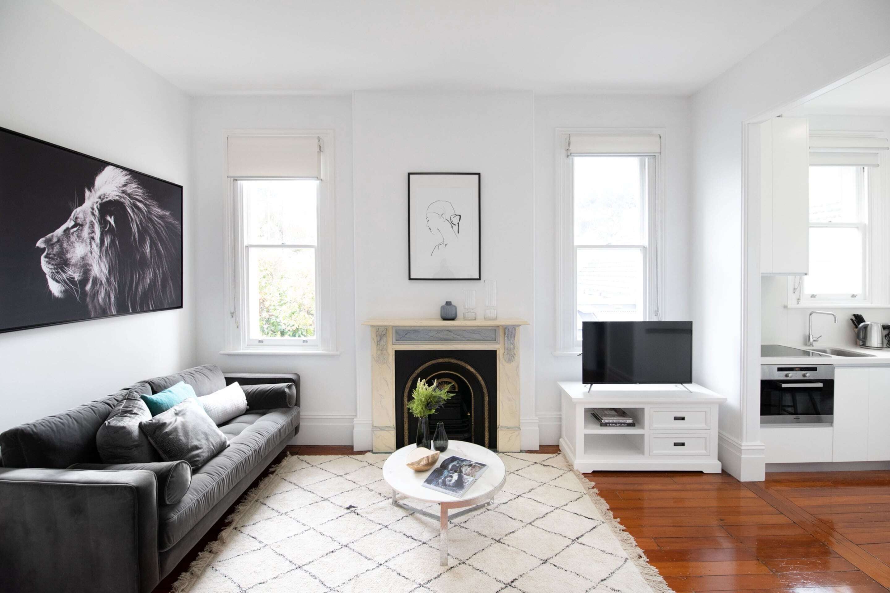 A modern living room with a fireplace, a sofa, a coffee table, and a television.