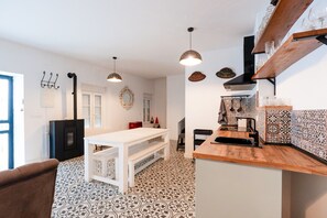 Una cocina moderna con una isla central, iluminación colgante y un suelo con diseño.